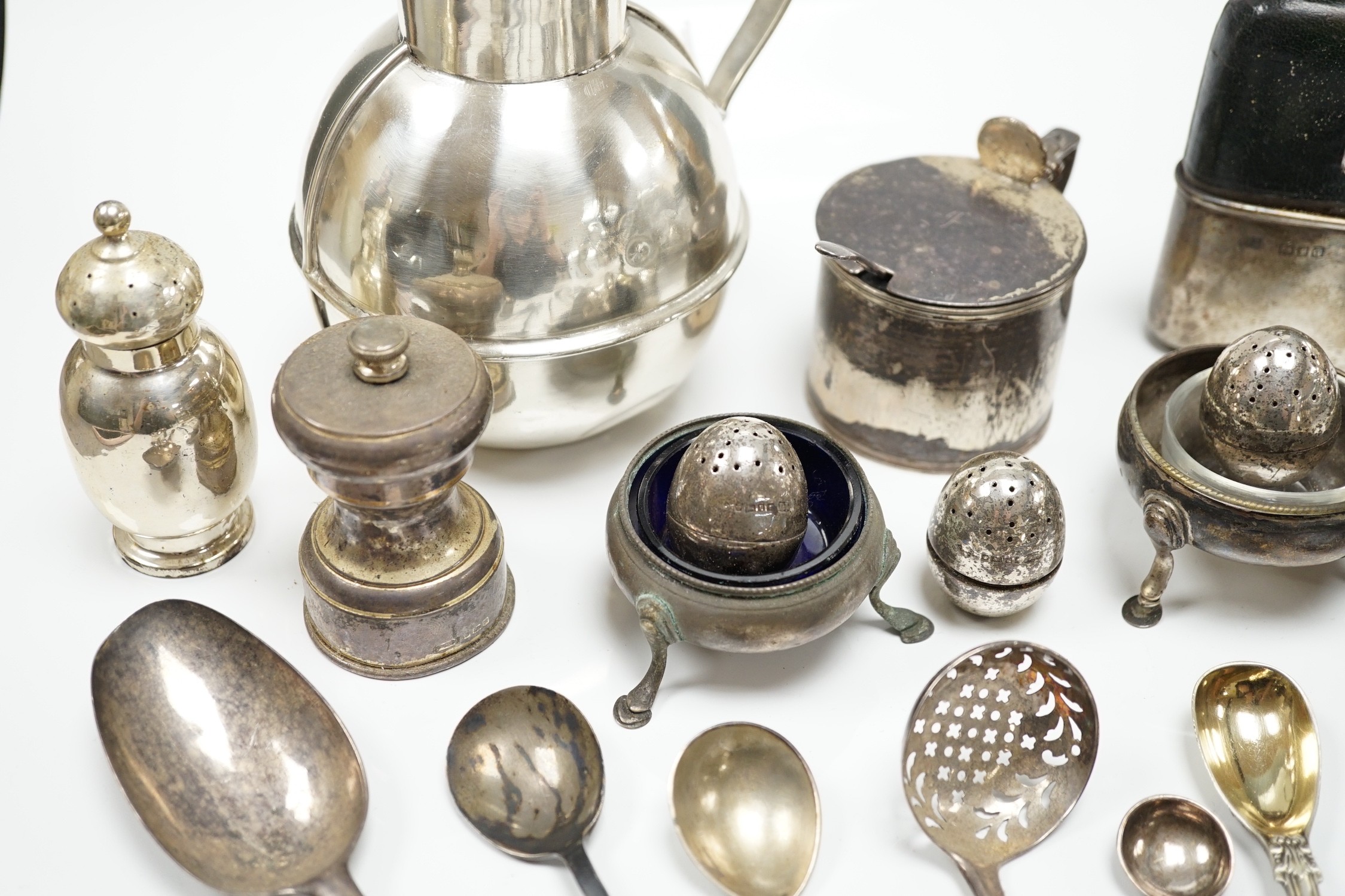 Sundry small silver including a Guernsey can milk jug, mustard pot, damaged mounted glass hip flask, flatware and minor plated wares.